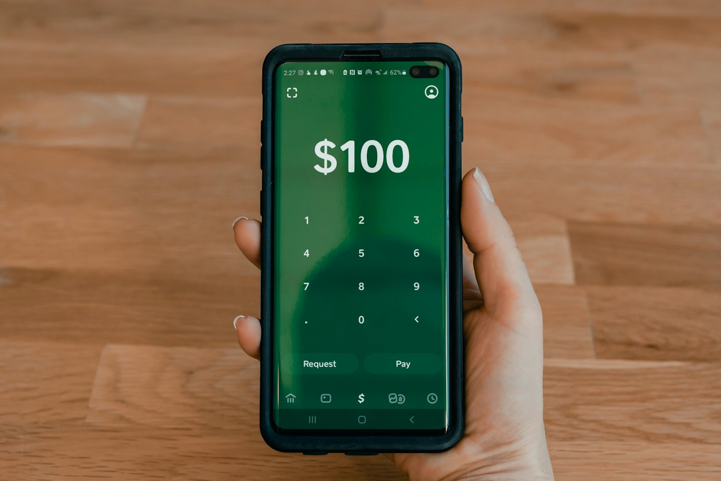 Mano sujetando un smartphone con una aplicación financiera abierta.