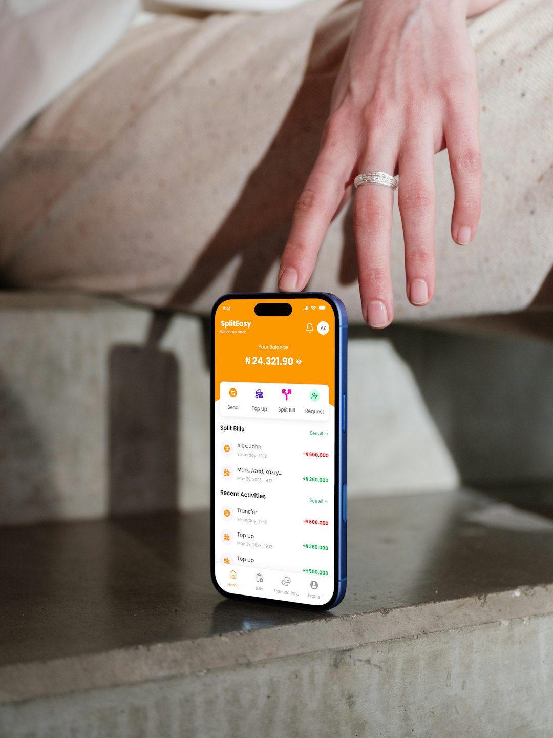 Una mano con anillo plateado toca la pantalla de un smartphone con datos financieros.